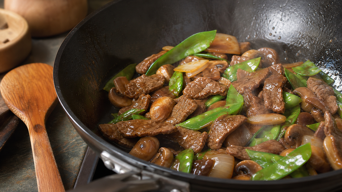 Glossy Chinese brown sauce coating beef, mushrooms and snow peas